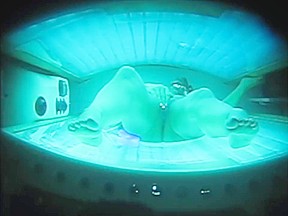 Peephole captures in tanning bed...