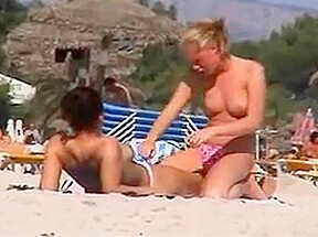 Two topless lesbian girls beach...