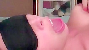 Blindfolded wifes face as she and...