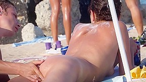 Junior woman nude sunbathing beach...