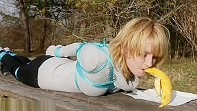 Cute girl eats banana while tied...